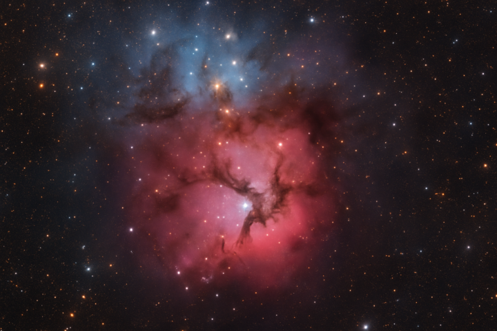 Gambar bintang muda di Nebula Trifid hasil pengamatan Teleskop Hubble dengan gas warna-warni dan jalur debu gelap
